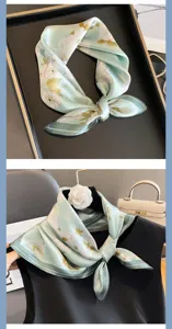 Vista dettagliata del foulard in seta verde menta con stampa floreale, ideale per camicie da lavoro.