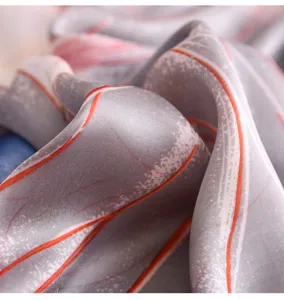 Elegant silk scarf detail close-up grey and orange abstract pattern soft fabric shawl