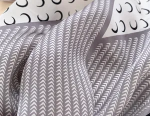 Silk square scarf detail shot featuring a stylish crescent moon and chevron pattern design.