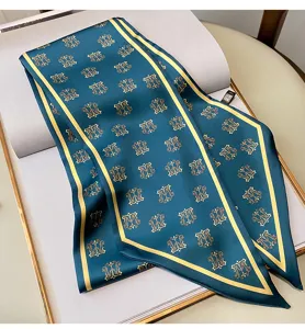 Vista dettagliata di foulard da donna in seta con elegante stampa monogramma e bordo dorato.