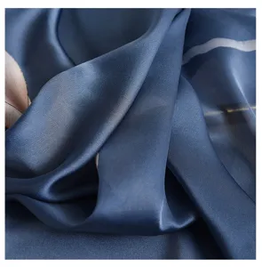 Detalle de bufanda de seda con tela azul suave, caída elegante y estampado estilo óleo.