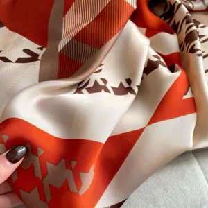 Elegant orange and brown geometric print long silk scarf, perfect for summer sun protection.