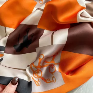 Elegant long silk scarf featuring classic equestrian geometric block design in orange and brown.