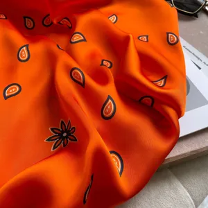 Orange satin silk scarf with paisley pattern, ideal summer sun protection shawl or beach wrap.