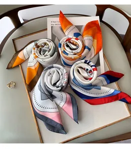 Detail view of stylish printed small square scarves, perfect as chic neckerchiefs or bag ribbons.