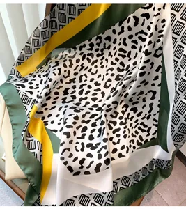 Dettaglio foulard quadrato con chic stampa leopardata e bordi geometrici a contrasto.