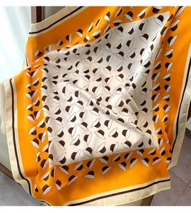 Silk scarf featuring a charming hat print pattern in yellow and white, offering elegant detail.