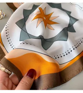 Silk square scarf with an abstract geometric star pattern in elegant autumn brown and orange tones.