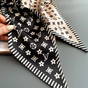 Silk scarf detail closeup, black and beige monogram pattern, elegant ribbon accessory for styling.