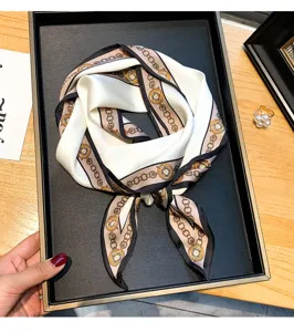 Detailed view of a vintage chain print silk scarf, elegant narrow ribbon for neck, hair or bag.