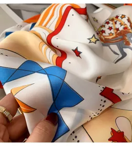 Close-up of silk scarf showing soft fabric texture, elegant equestrian and geometric print.