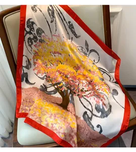 Vista dettagliata del foulard quadrato in seta con stampa floreale e bordo rosso.