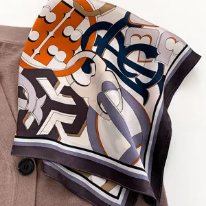 Close-up detail of luxury style silk square scarf with elegant geometric print design.