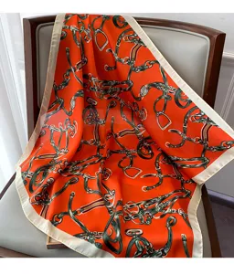 Foulard quadrato in raso arancione con stampa equestre classica, dettaglio sulla sedia.