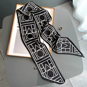 Detailed view of black and white geometric print silk twilly scarf, elegant neck ribbon.