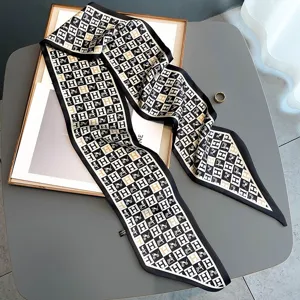 Close-up detail of luxury black and white silk twilly scarf with classic H and horse motif.