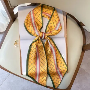 Elegante foulard in seta stretto con motivo geometrico giallo da donna, ideale come sciarpa o fascia.