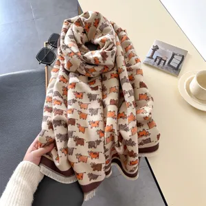 Primo piano della sciarpa invernale accogliente effetto cashmere con frange e stampa di mucche.