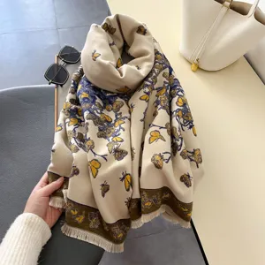 Detailed view of beige cashmere feel scarf with blue yellow butterfly print fringe edge cozy.