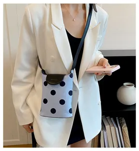 Close-up view of the casual polka dot crossbody bag worn by model, showing texture.