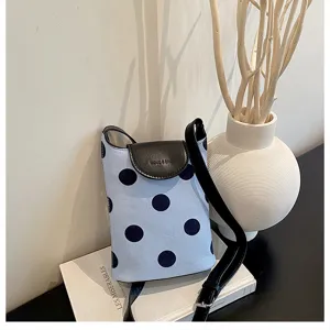 Light blue polka dot linen shoulder bag with black flap and adjustable strap for women.