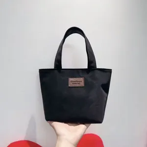 Black PU handbag detail, minimalist tote design, compact yet spacious hand-held daily bag.