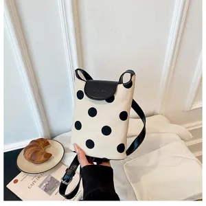Canvas polka dot shoulder bag with black leather flap, trendy casual crossbody handbag detail.