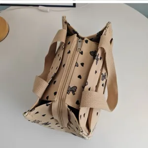 Canvas tote bag with cute black heart and bow print, perfect lunch bag for daily commute.