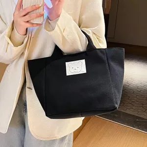 Japanese style small black canvas tote bag with cute bear patch for women daily commute.