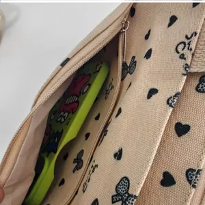Canvas handbag with cute bow and heart print, large capacity commuter tote bag detail.