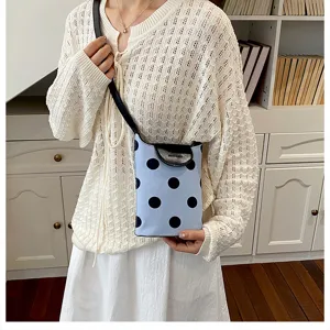 Casual canvas shoulder bag featuring black polka dots and stylish leather flap closure.