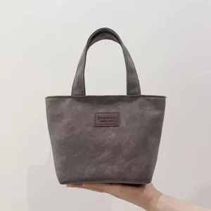 Detailed close-up view of the dark gray PU tote bag handle and front brand logo patch.