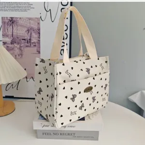 Canvas tote bag with bow and heart print, large capacity handbag for office commuting and daily use.