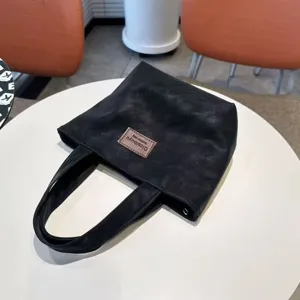 Close-up detail of the black PU tote bag, featuring durable stitching and soft texture.