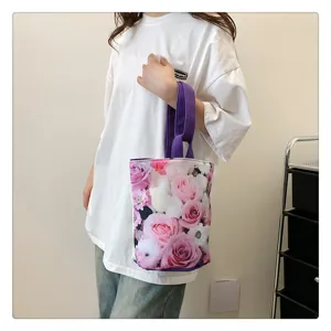Detailed shot of the floral canvas bucket bag, showing vibrant rose print and purple handle.