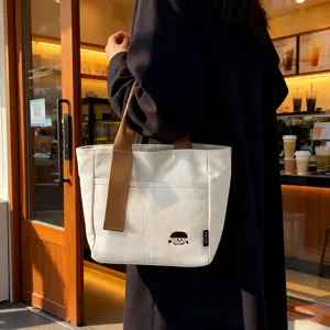 Casual canvas tote bag with thick fabric, front pocket and contrast handles for daily use.