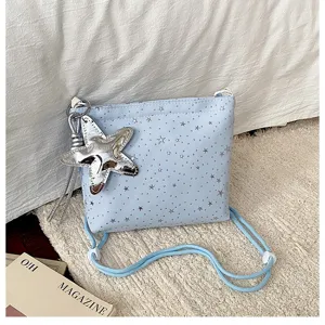 Detail view of light blue star print crossbody shoulder bag with silver star pendant.