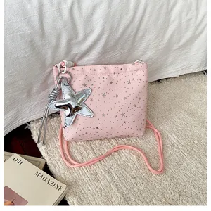 Pink star shoulder bag detail view, featuring silver star pendant and soft fabric material.