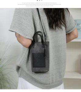 Mini crossbody phone bag for women, stylish dark grey small bucket handbag with front pocket.