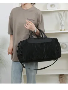 Detail shot of a black PU travel duffel bag held by a model, showing capacity and strap.
