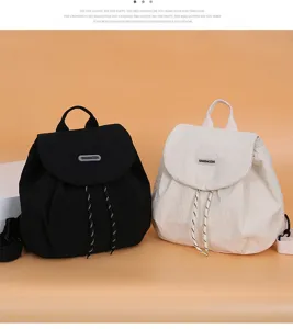 Detailed view of casual canvas backpack with drawstring and flap design in black and beige.