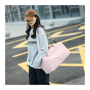 Lightweight pink cylindrical travel duffel bag and gym bag with comfortable strap for sports.
