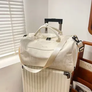 Detail shot of the large capacity white travel duffel bag showing its texture, straps and zips.