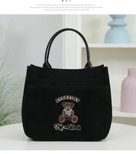Vue détaillée du sac fourre-tout noir en toile PU avec broderie d'ours et grande capacité.