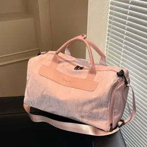 Detailed view of the pink travel duffel bag showing textured fabric and sturdy handles.