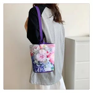 Floral canvas bucket bag for women, casual lightweight tote handbag with purple straps.