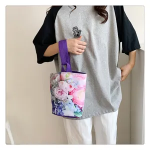 Floral print canvas bucket bag with purple handle, lightweight handheld bento handbag for women.