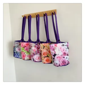 Floral print canvas handbag detail, featuring vibrant rose patterns and purple handles.