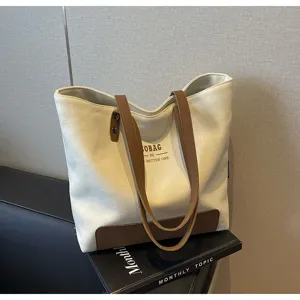 Casual canvas tote bag with brown leather contrast handles and minimalist daily commuter style.