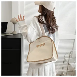 Korean style canvas shoulder bag with cute bear embroidery and brown piping for daily use.